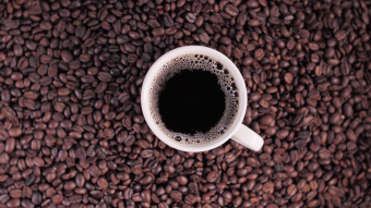 上帝视角旋转近摄一杯浓咖啡放在咖啡豆上