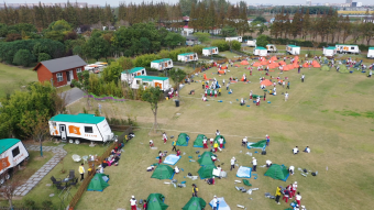 高清航拍学生在营地搭帐篷