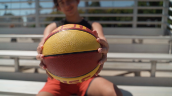 男孩双手举着一个篮球实拍视频素材