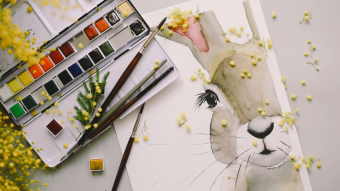 桌子上摆放的画笔和完成的画作实拍视频素材